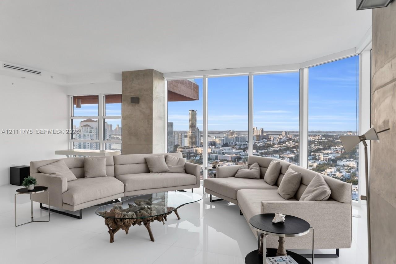 Floor-to-ceiling glass walls, polished stone-finish flooring, and exposed concrete structural column