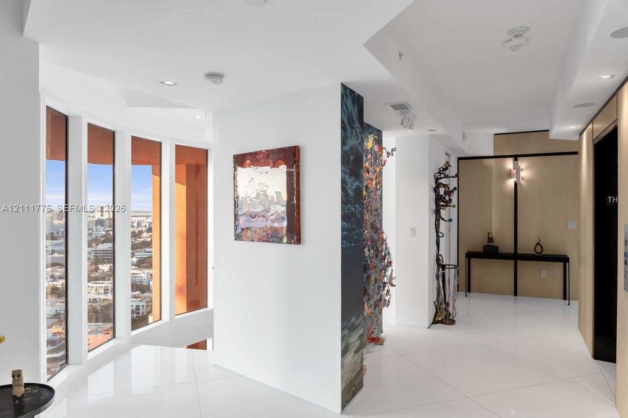 Floor-to-ceiling windows, high-gloss tile flooring, recessed ceiling lighting, and decorative wall paneling
