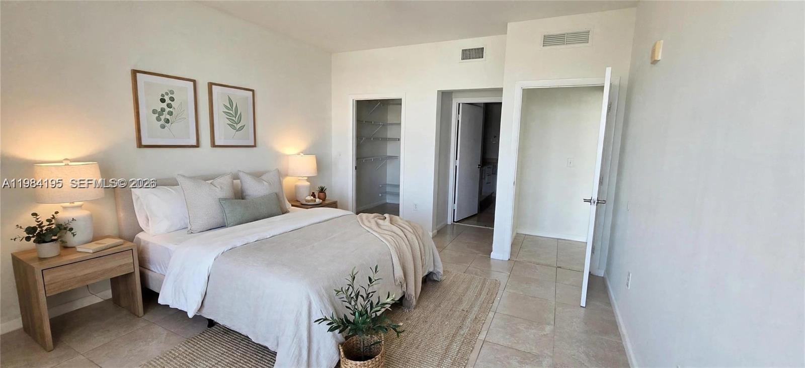 Spacious room featuring neutral tile flooring, neutral wall tones, and built-in closet storage
