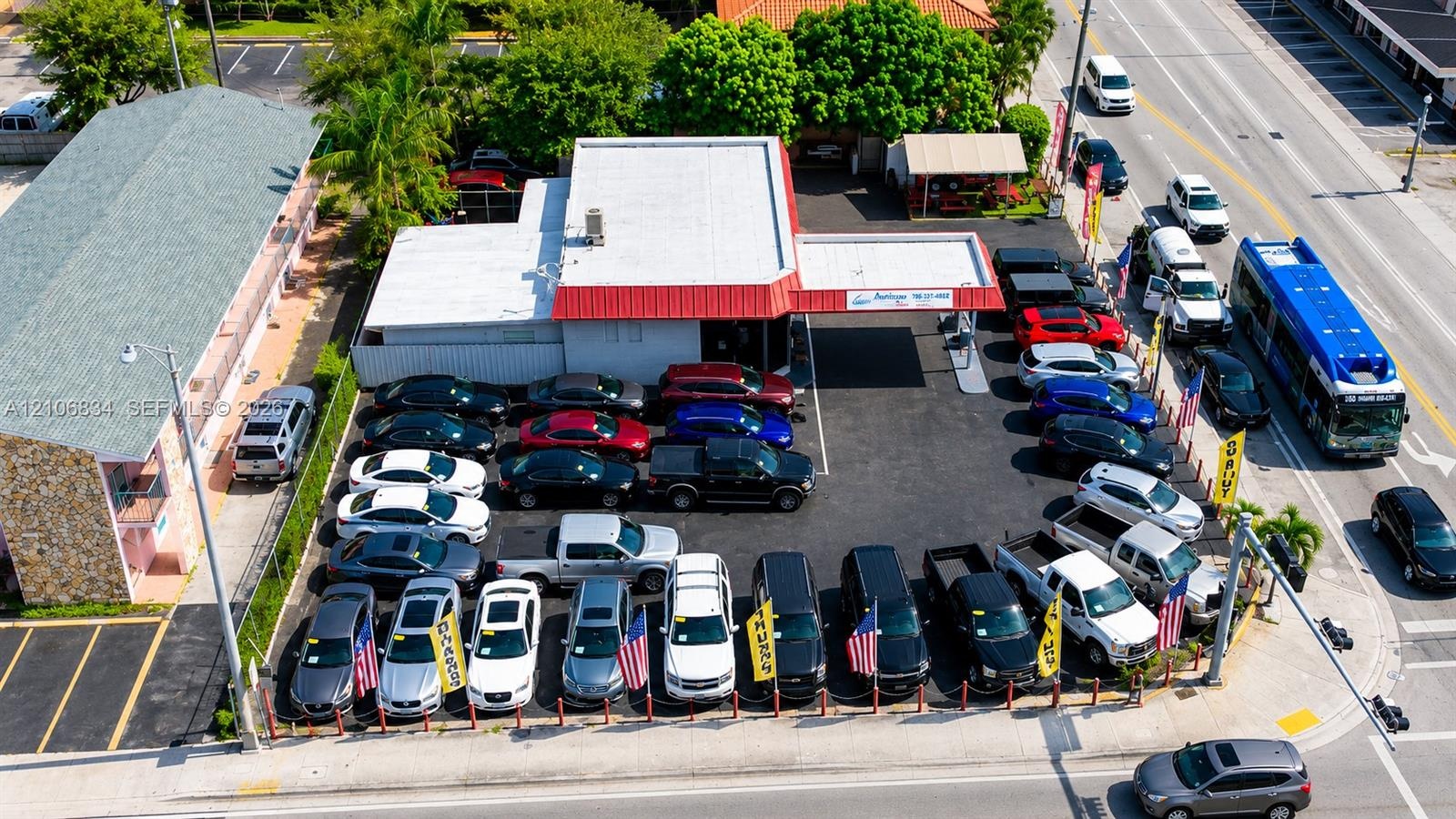 Commercial property featuring a flat-roof structure with a covered drive-through canopy and paved asphalt lot