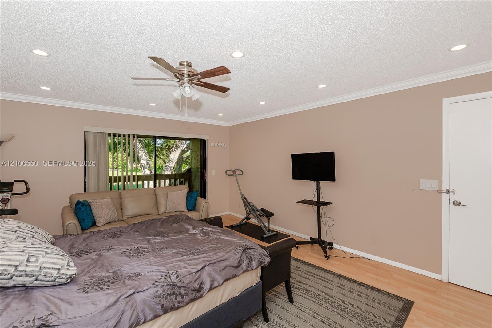 Primary Bedroom featuring wood-finish flooring, recessed lighting, a ceiling fan with integrated light kit, and a sliding glass door