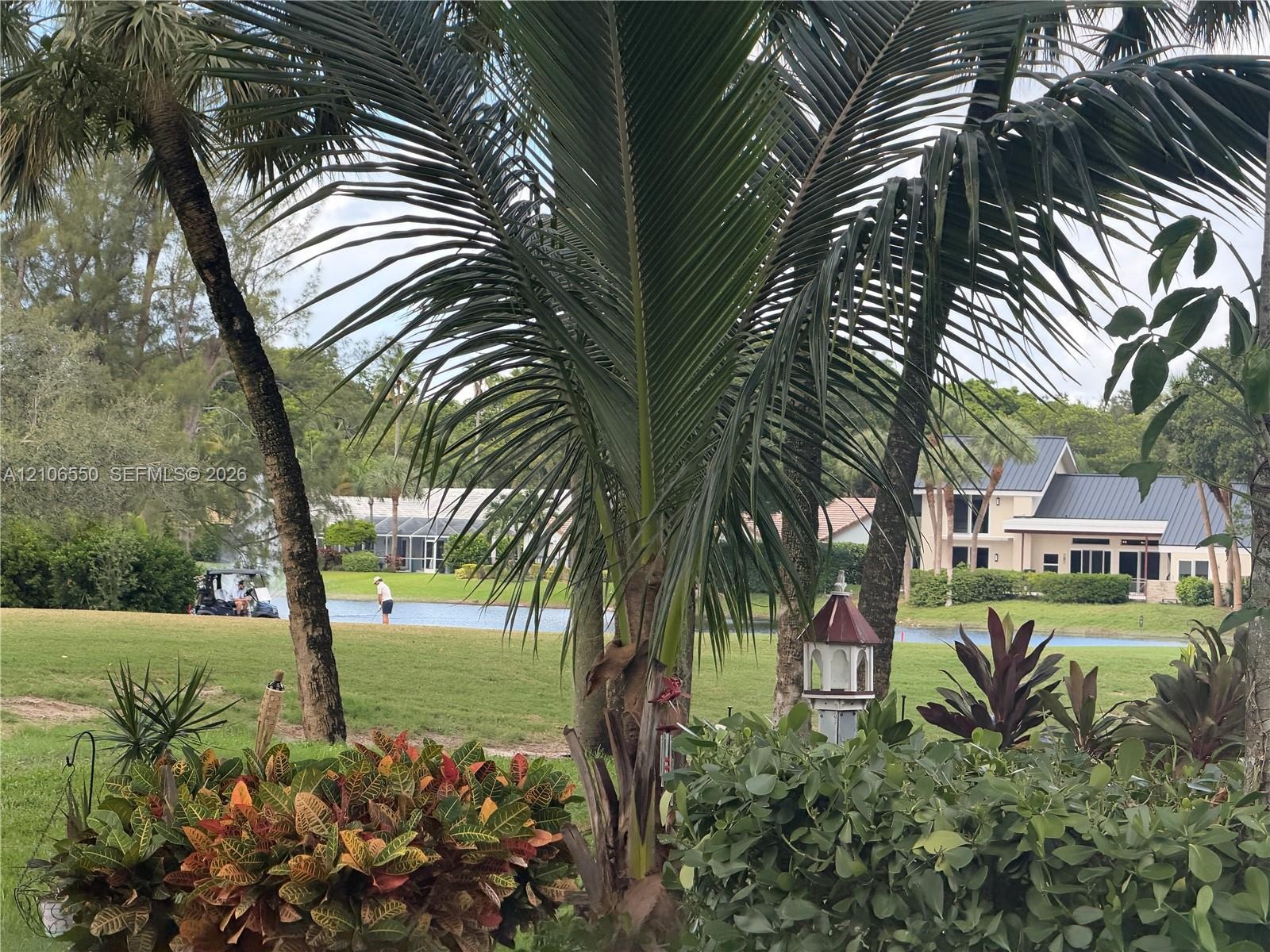 Exterior featuring mature tropical landscaping, palm trees, and a water feature