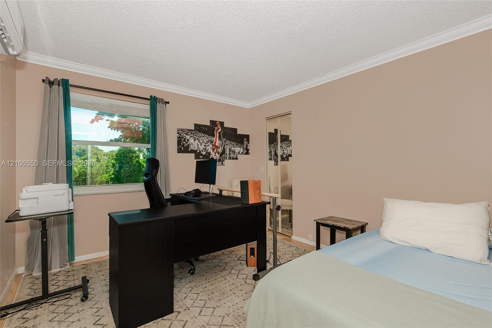 Room featuring neutral-toned walls, crown molding, a large single-pane window, and mirrored sliding closet doors