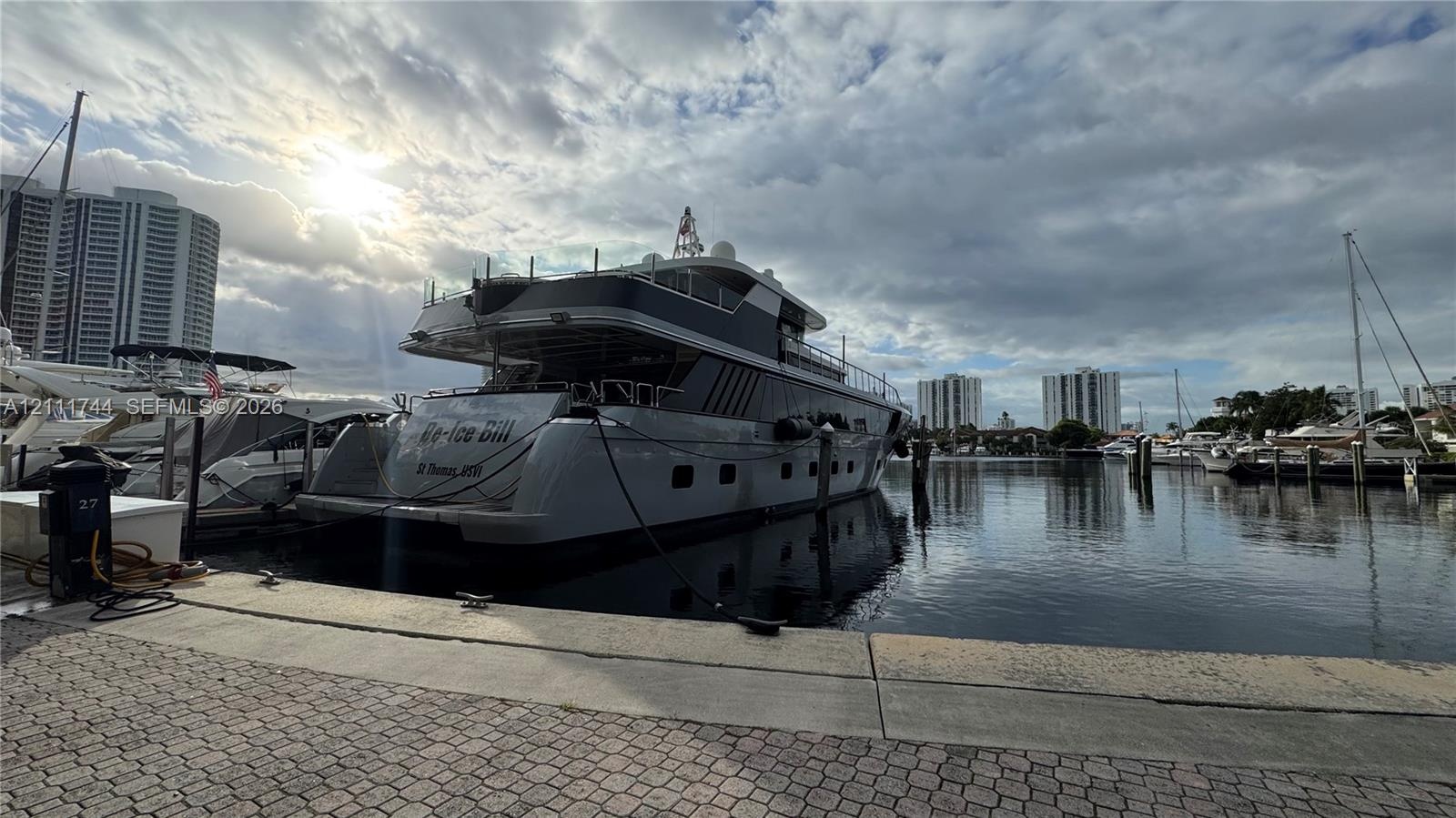 Deep-water marina slip featuring concrete bulkhead, paved brick apron, and mooring cleats