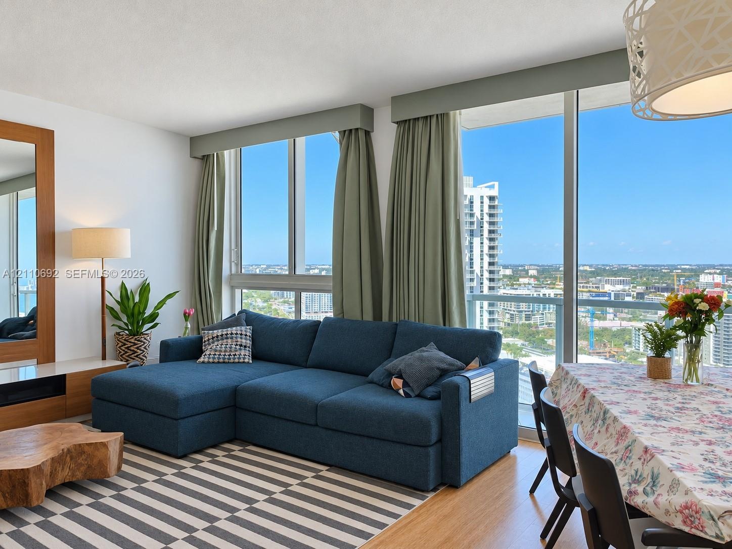 Floor-to-ceiling windows, wood-finish flooring, built-in wooden media console, and recessed lighting