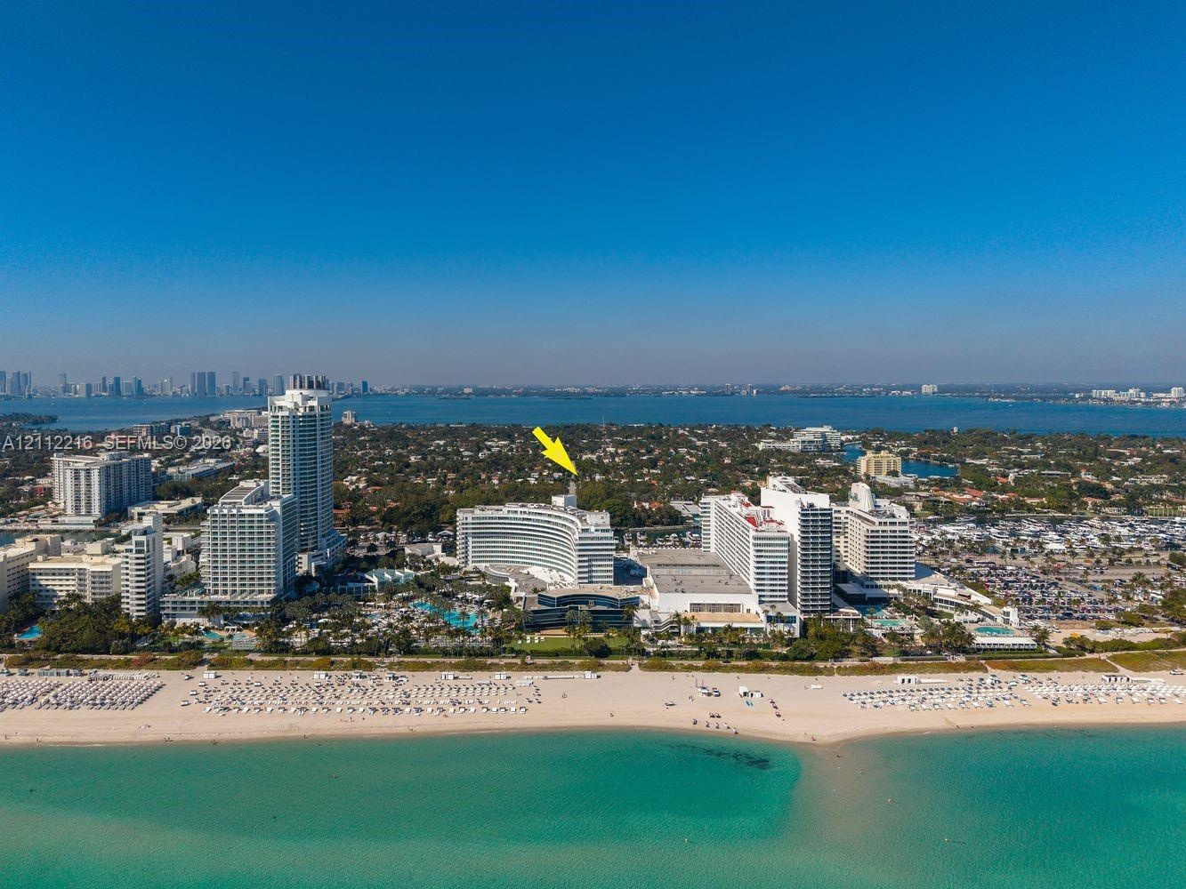 Aerial perspective of a coastal high-rise location featuring immediate proximity to oceanfront beaches and surrounding urban infrastructure