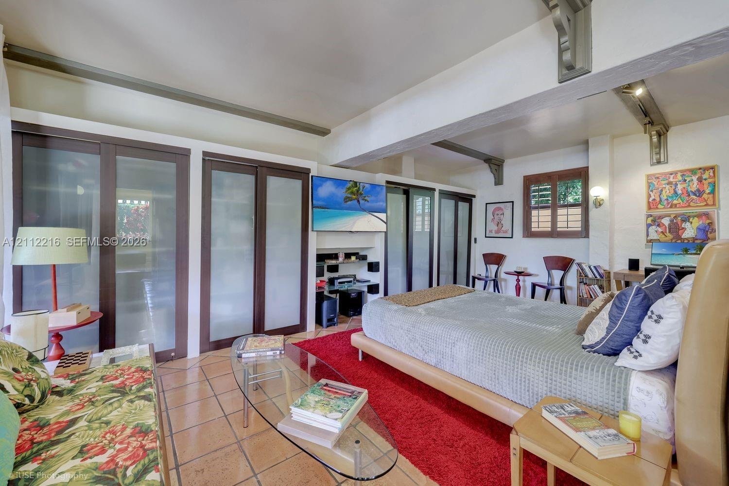 Tile flooring, exposed wood ceiling beams, built-in floor-to-ceiling storage with frosted glass panels, and a wall-mounted display nook