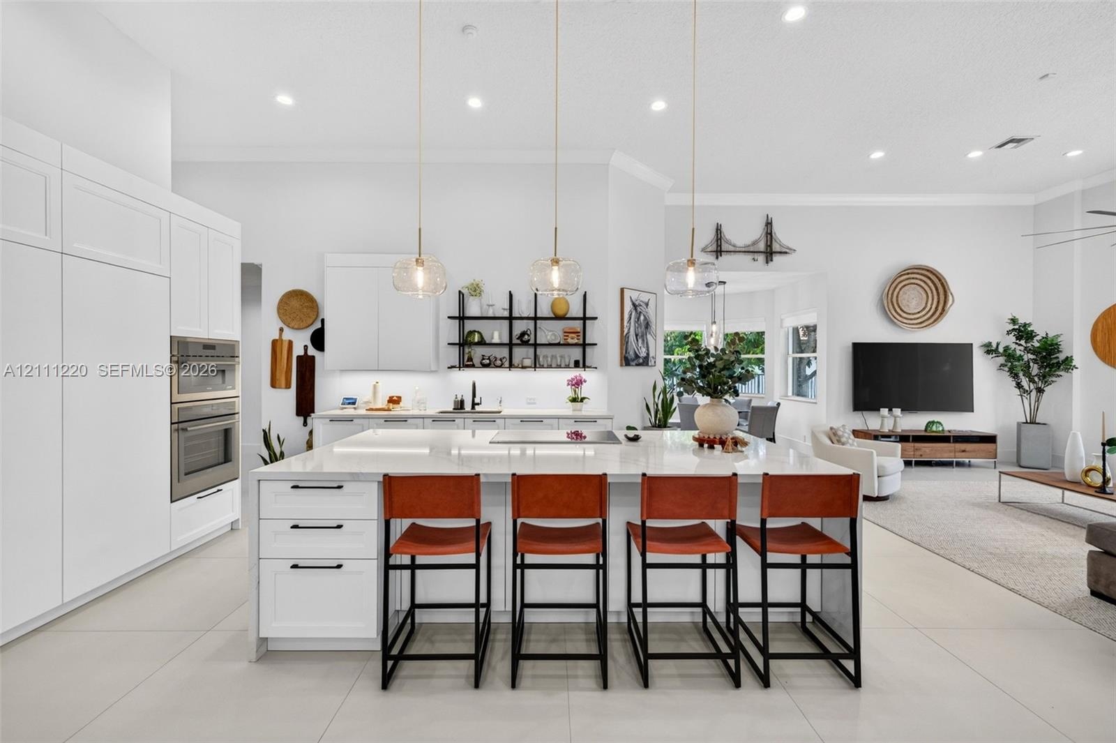 Kitchen featuring white shaker-style cabinetry, a large central island with a stone countertop, built-in stainless steel double ovens, recessed lighti