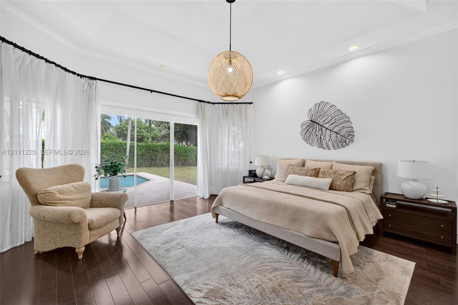 Tray ceiling with recessed lighting, dark wood-finish flooring, and sliding glass doors opening to an exterior swimming pool