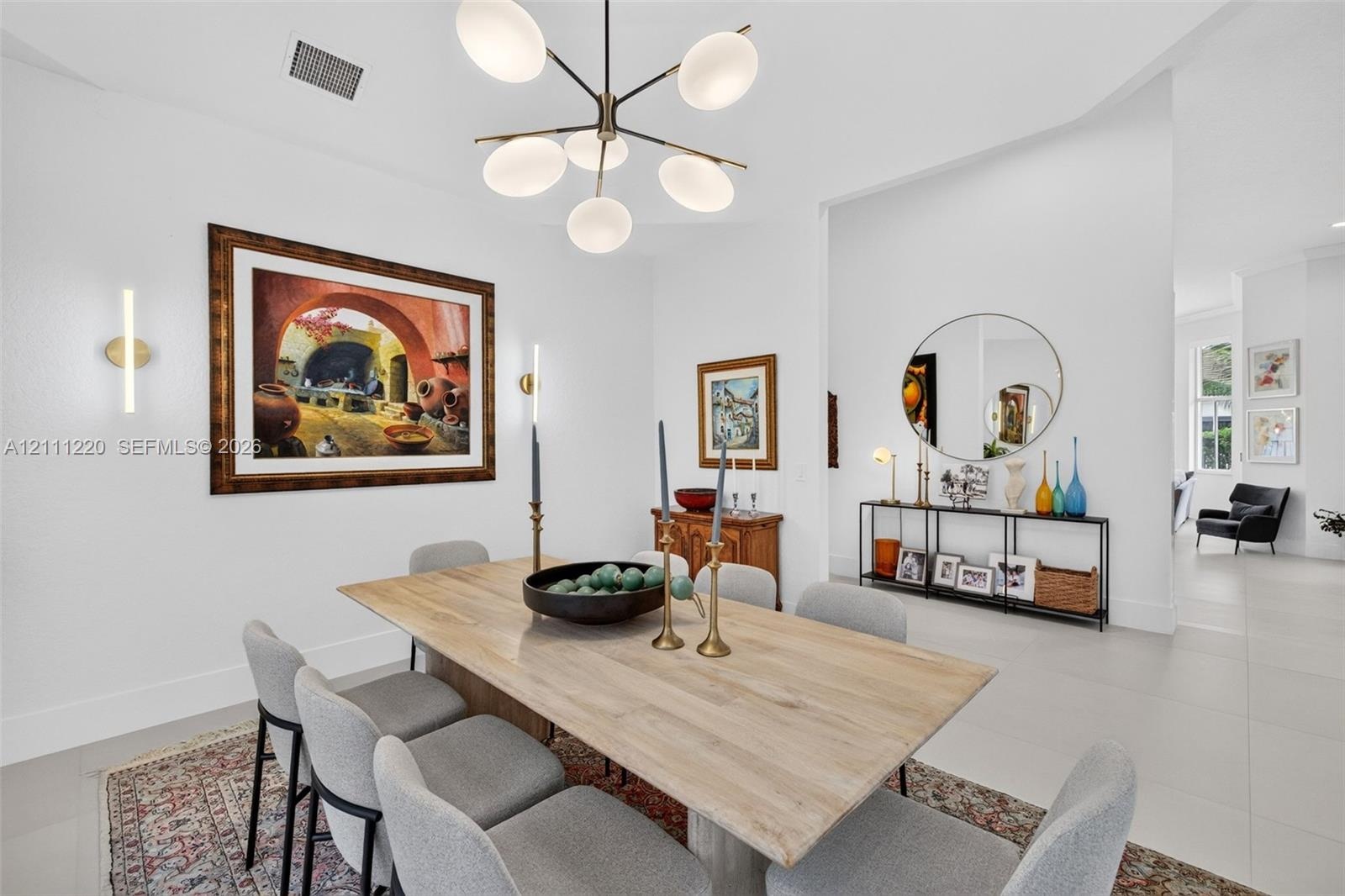 Multi-arm contemporary chandelier with opal glass shades, neutral large-format tile flooring, and integrated wall-mounted linear light fixtures
