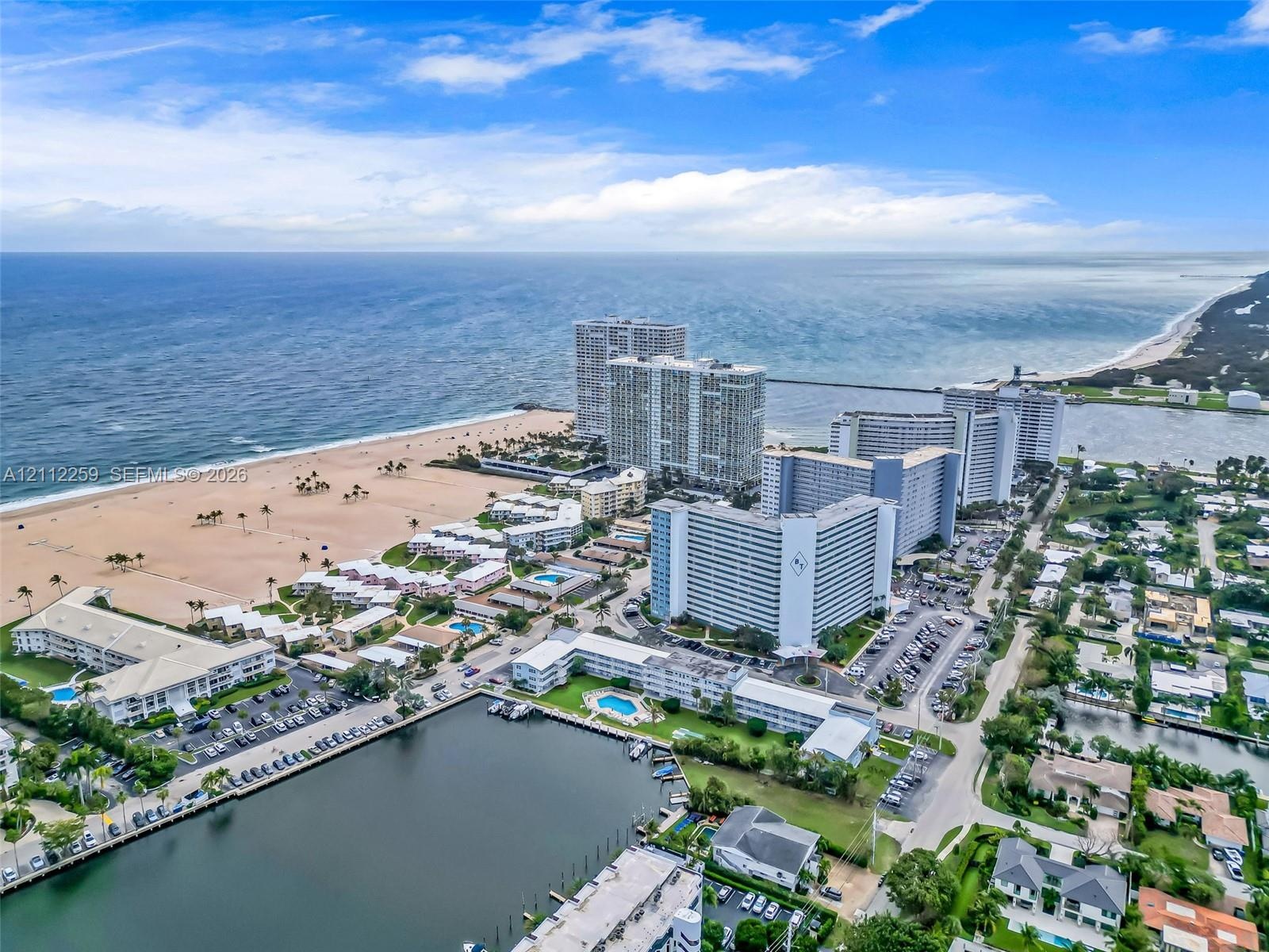 Aerial perspective featuring coastal shoreline, ocean access, waterway inlet, and multi-story residential structures