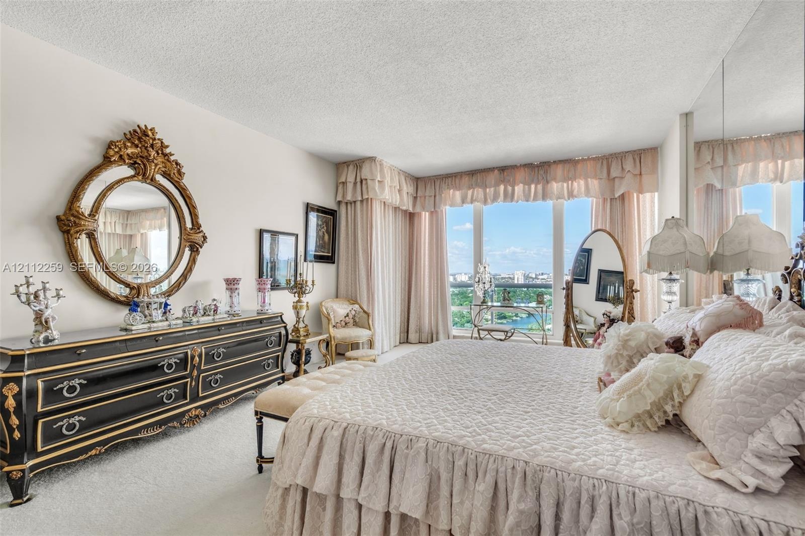 Floor-to-ceiling windows featuring exterior scenery, neutral carpeting, and a mirrored wall panel