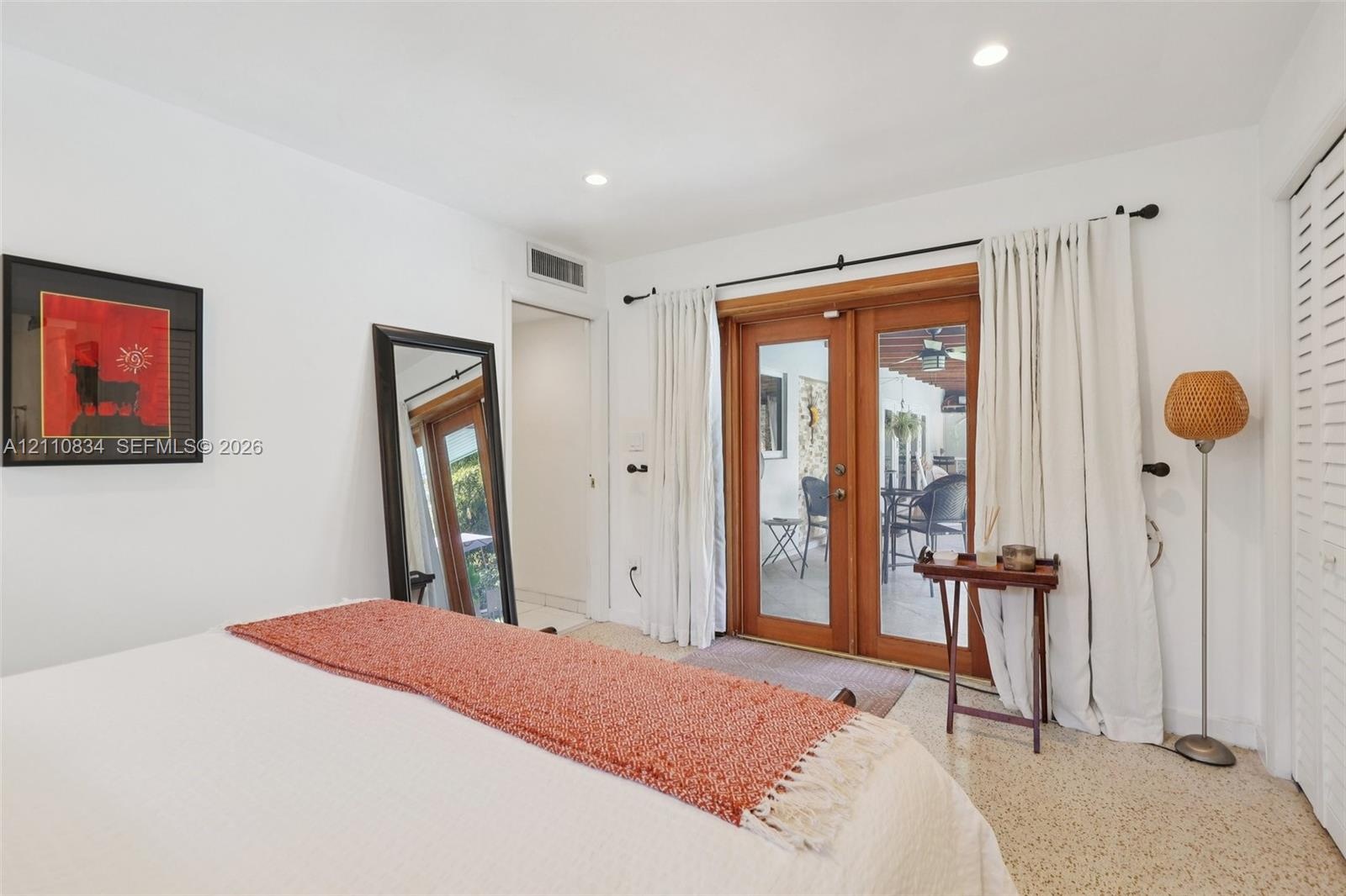 Interior space featuring glass-paned wood-framed double doors, recessed lighting, and terrazzo flooring