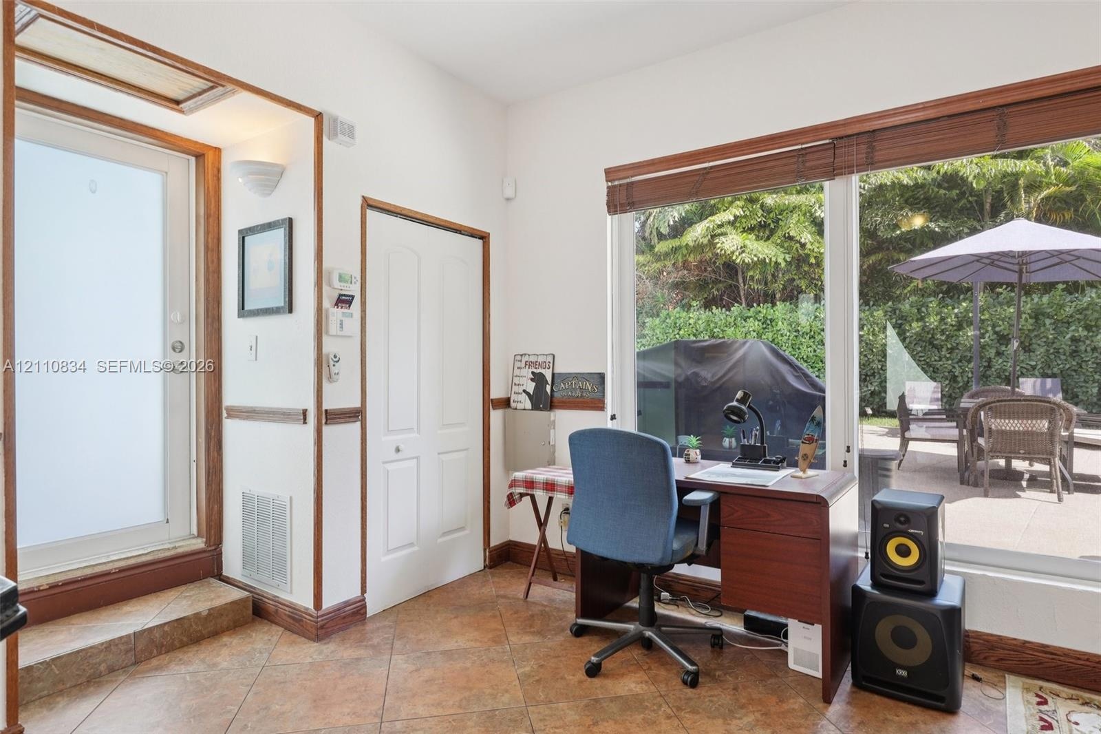 Tile flooring, wood-trimmed door frames, and a large sliding glass door