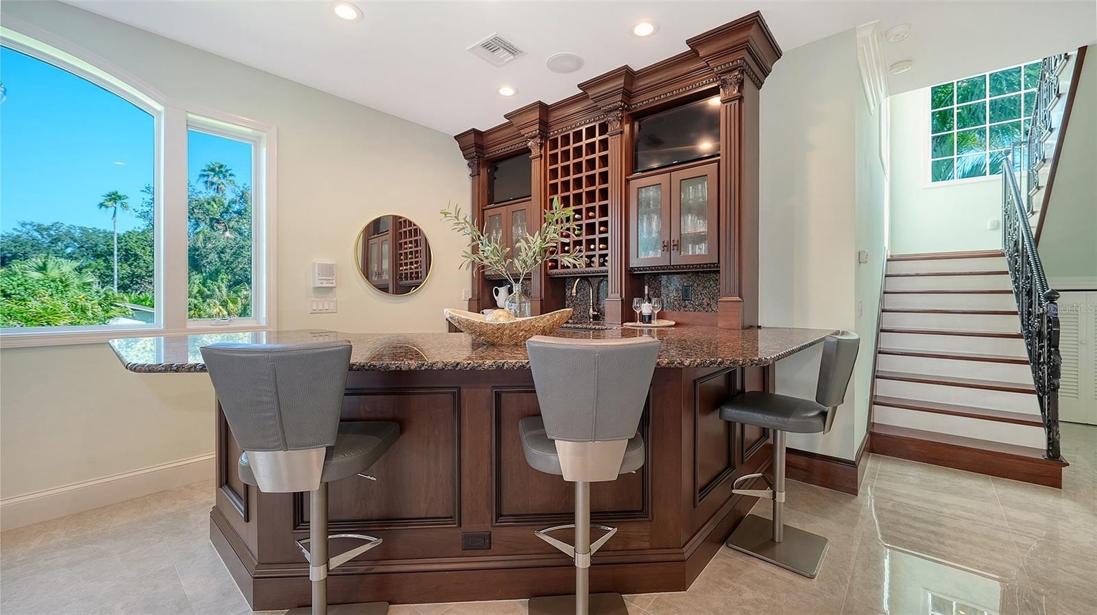 custom bar ideal for entertaining, stairs lead to second floor private owners suite
