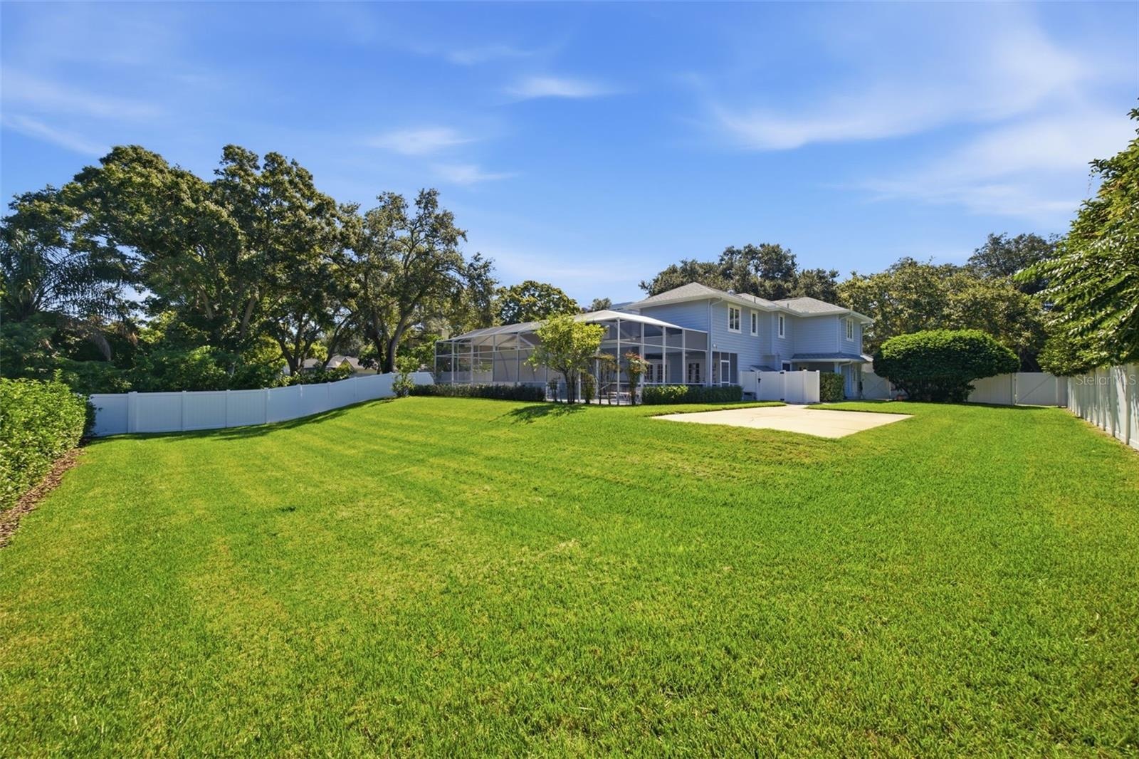 Large fenced backyard with mature landscaping