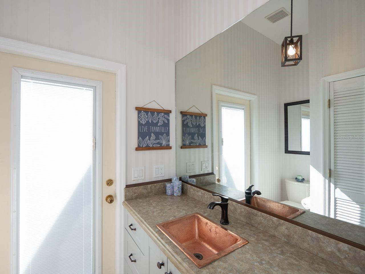 1/2 bath adjacent to laundry room with door out to pool area