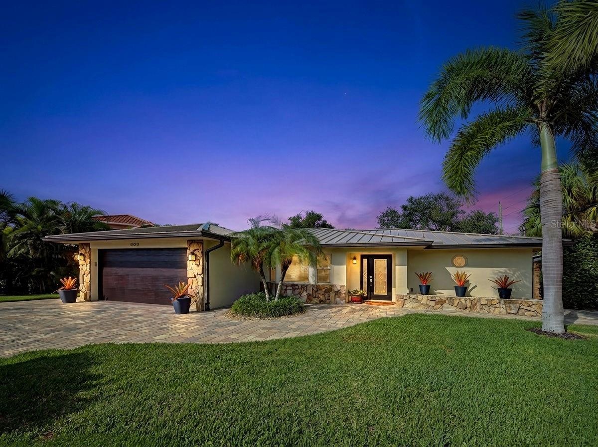 Front of home has paver driveway and beautifully landscaped.