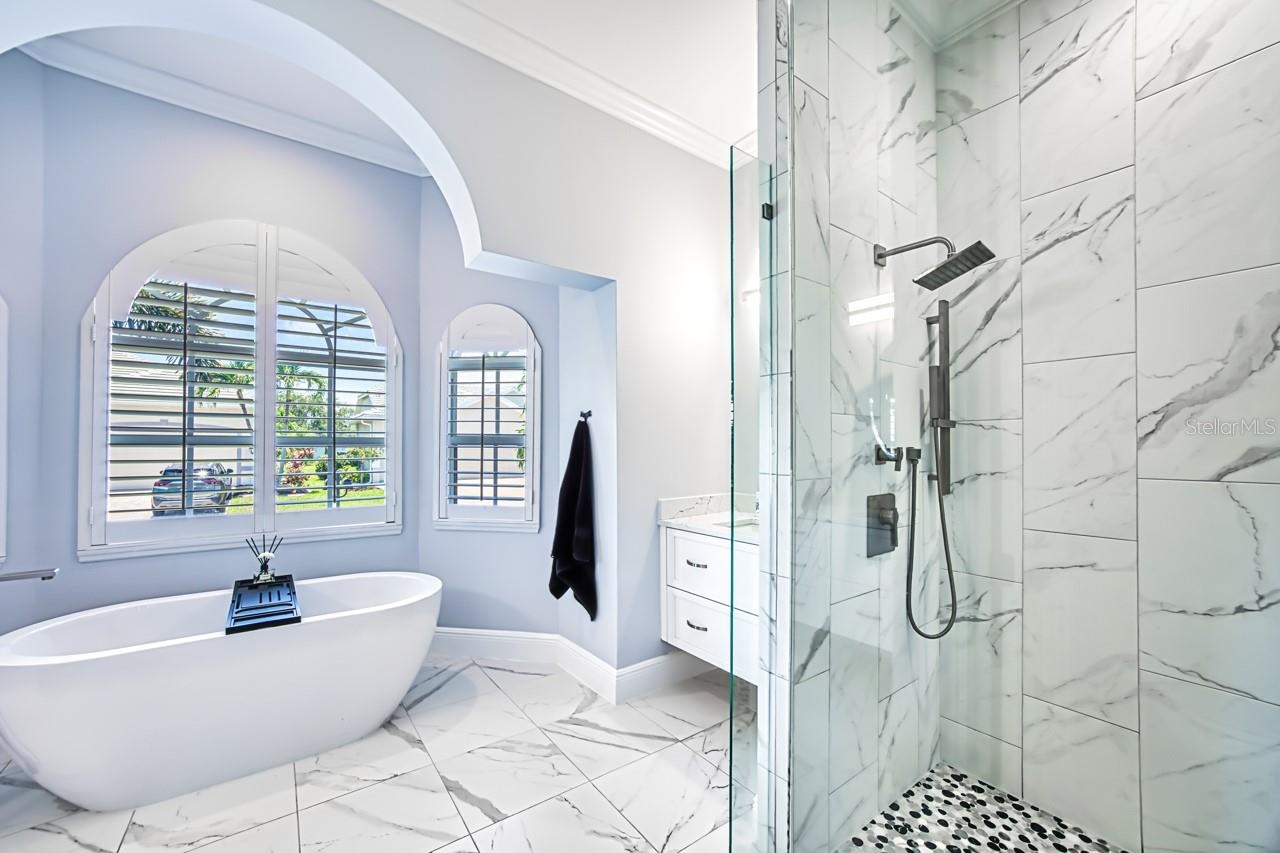 Updated primary bath with walk in shower and separate tub.  Wall mounted vanities