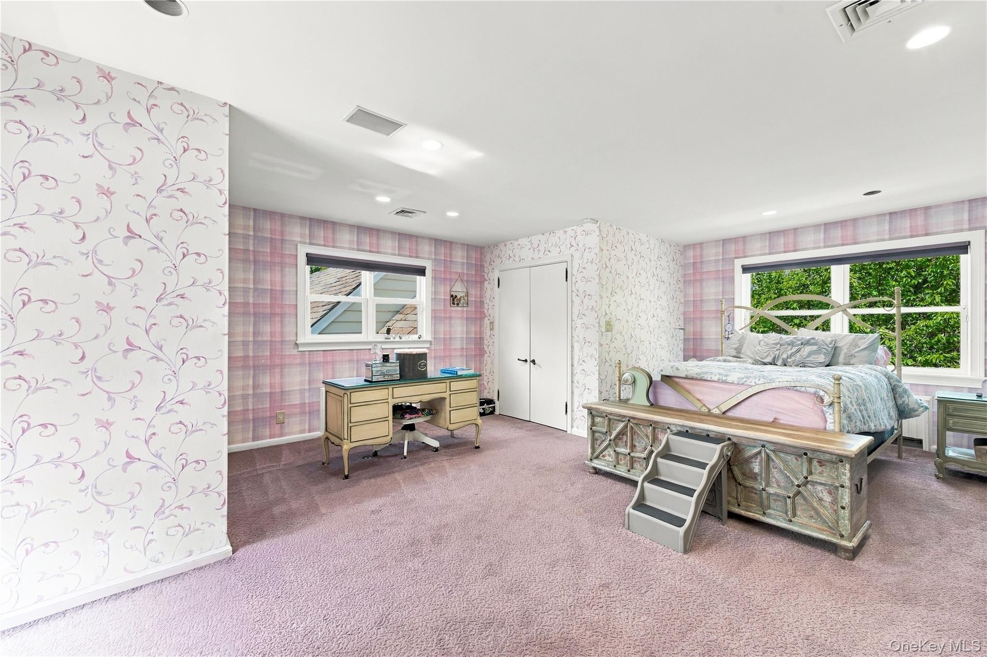 Spacious interior featuring patterned wallpaper, recessed lighting, carpeted flooring, and dual double-pane windows