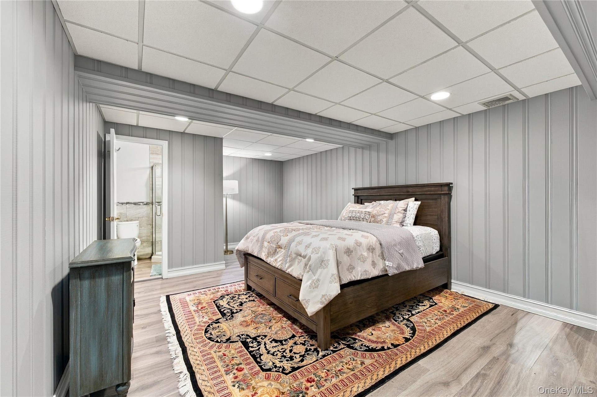 Vertical paneling, wood-finish flooring, recessed lighting, and a drop ceiling
