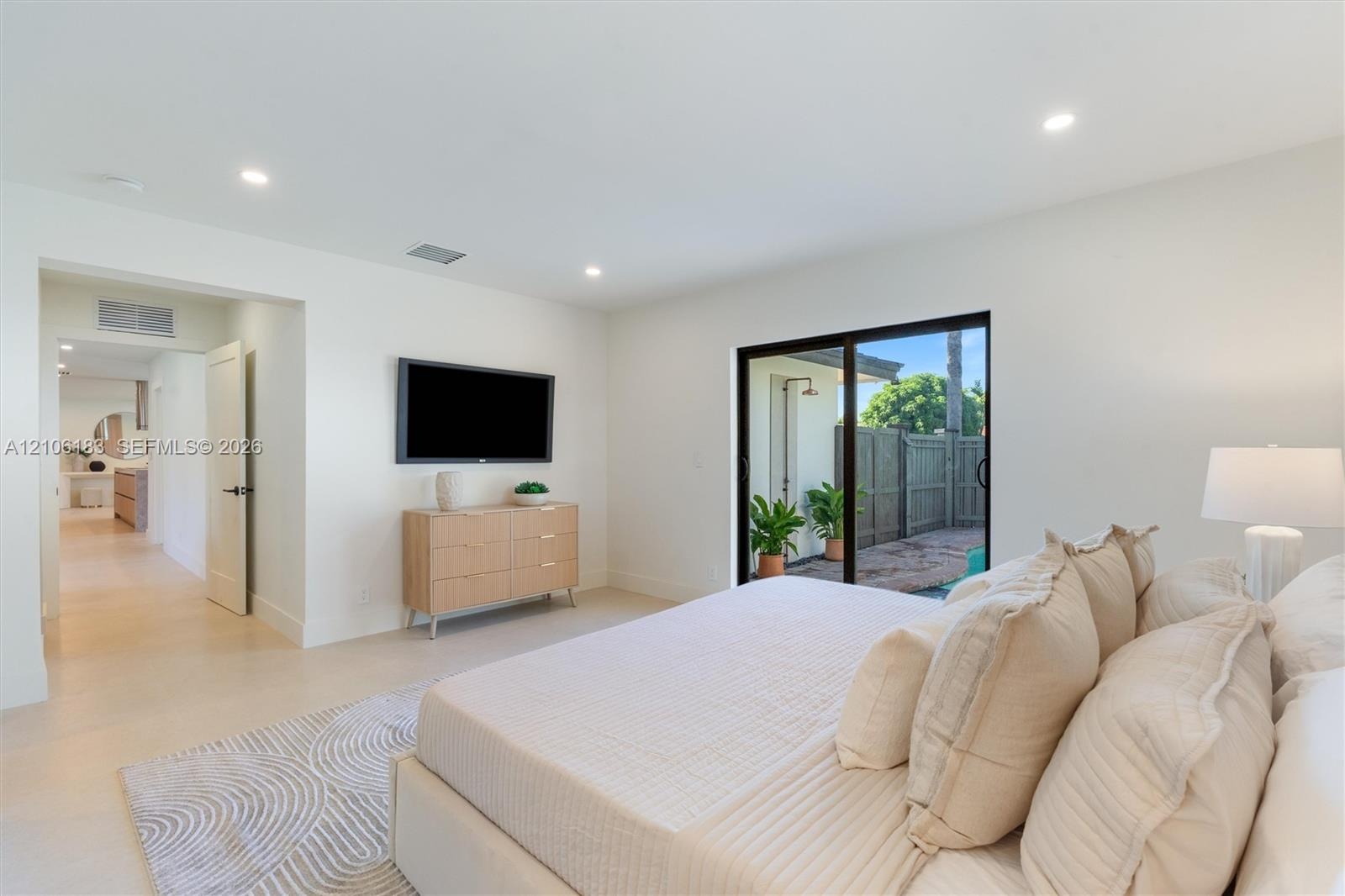 Neutral interior featuring recessed lighting, large-format tile flooring, and a glass sliding door providing exterior access