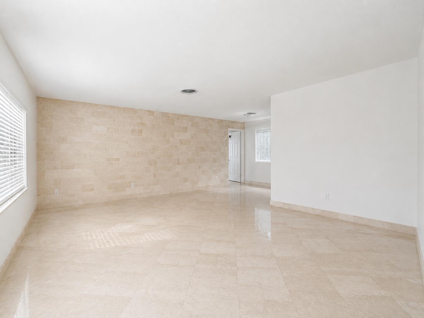 Recessed ceiling lighting, tiled flooring, tiled accent wall, and window with horizontal blinds