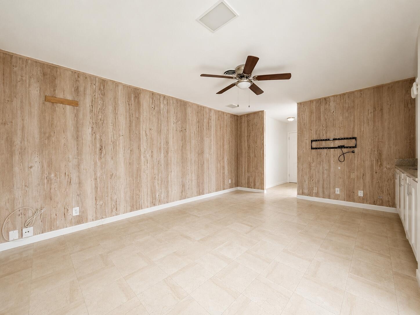 Wood-finish wall paneling, tiled flooring, and a ceiling fan
