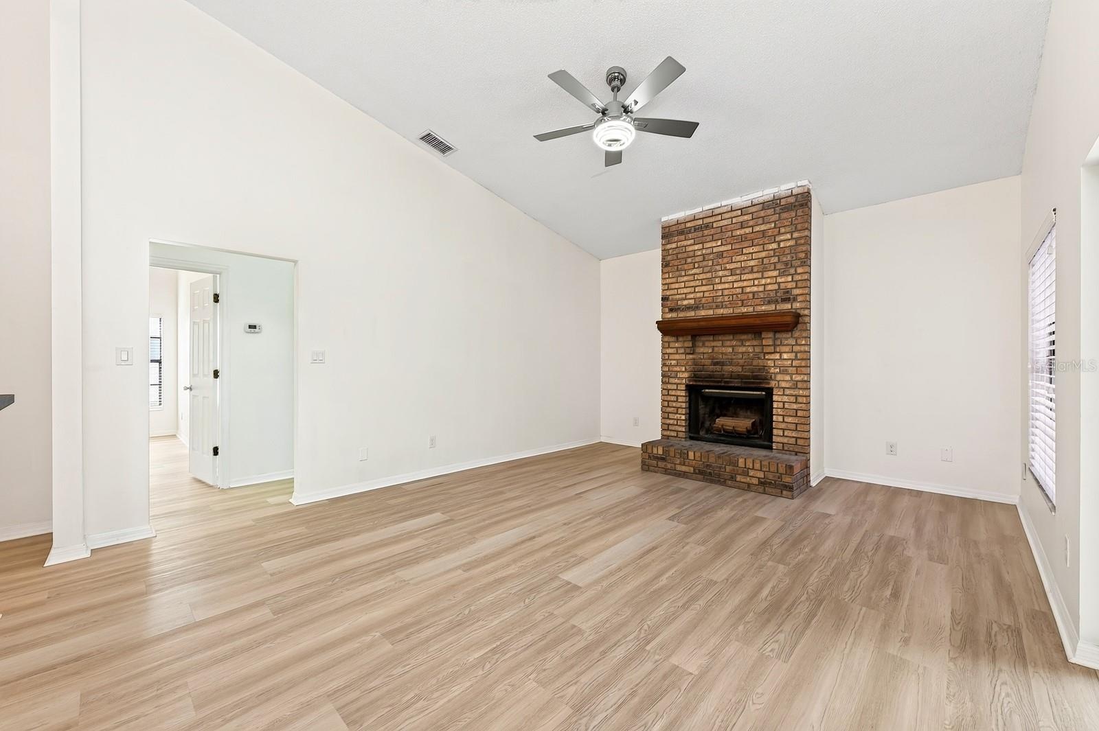 In the Family Room, a WOOD-BURNING FIREPLACE creates a cozy focal point, and sliding glass doors provide another EASY CONNECTION to the outdoor living