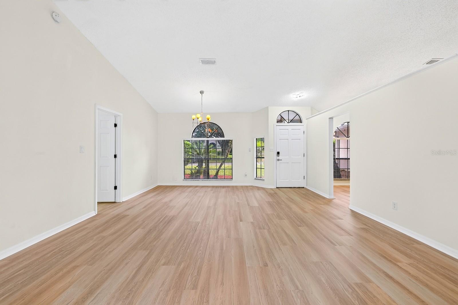 The formal Dining Room features an ELEGANT ARCHED LUNETTE WINDOW and flows into the Living Room.