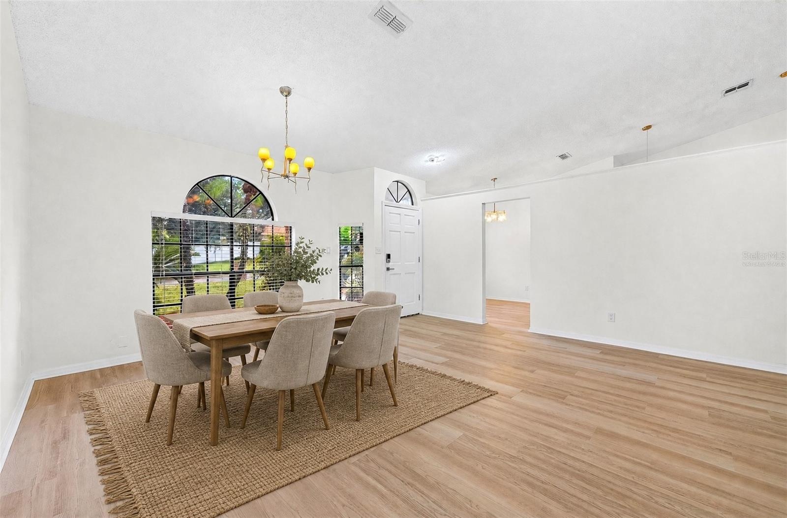 The formal Dining Room features an ELEGANT ARCHED LUNETTE WINDOW and flows into the Living Room. Virtually Staged