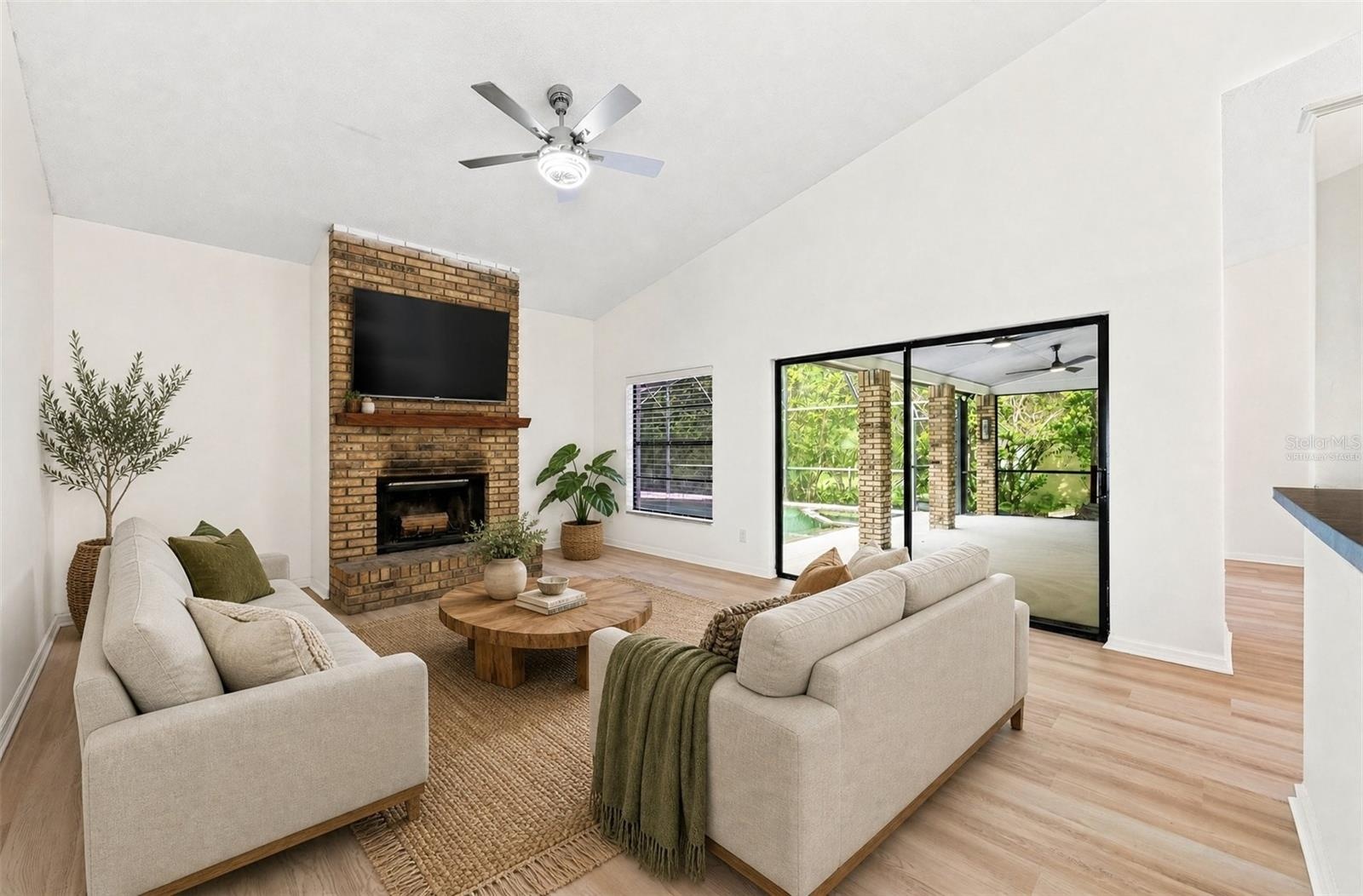 In the Family Room, a WOOD-BURNING FIREPLACE creates a cozy focal point, and sliding glass doors provide another EASY CONNECTION to the outdoor living