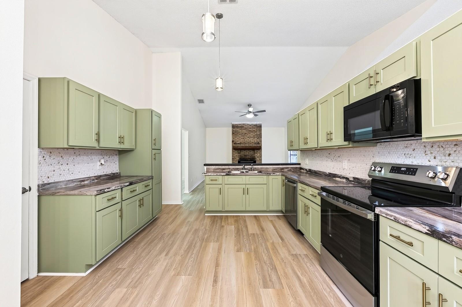 The beautifully REFRESHED KITCHEN offers an abundance of NEW CABINETRY and counter space, a convenient breakfast bar and NEW STAINLESS STEEL APPLIANCE