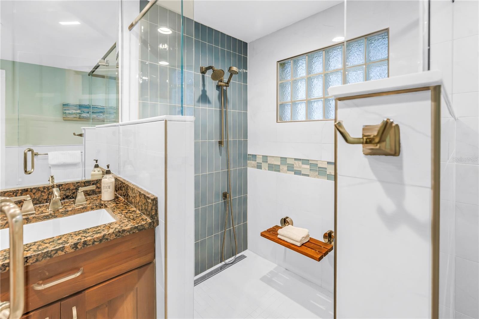 Exquisite spa-inspired walk-in shower featuring a built-in bench and a handheld shower wand.