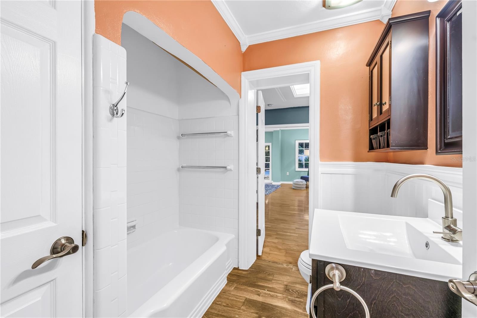 The Jack and Jill bathroom features a recently refinished shower, a modern updated vanity, and a convenient linen closet.