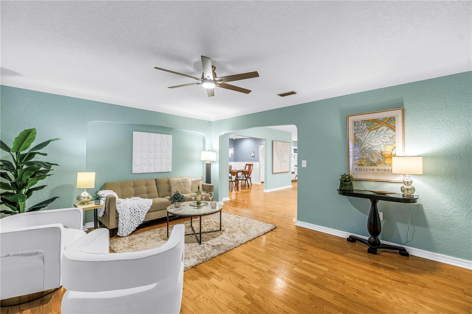 Formal living room with elegant crown molding, modern paint, updated fixtures, and an open layout in an exceptionally well-maintained home.