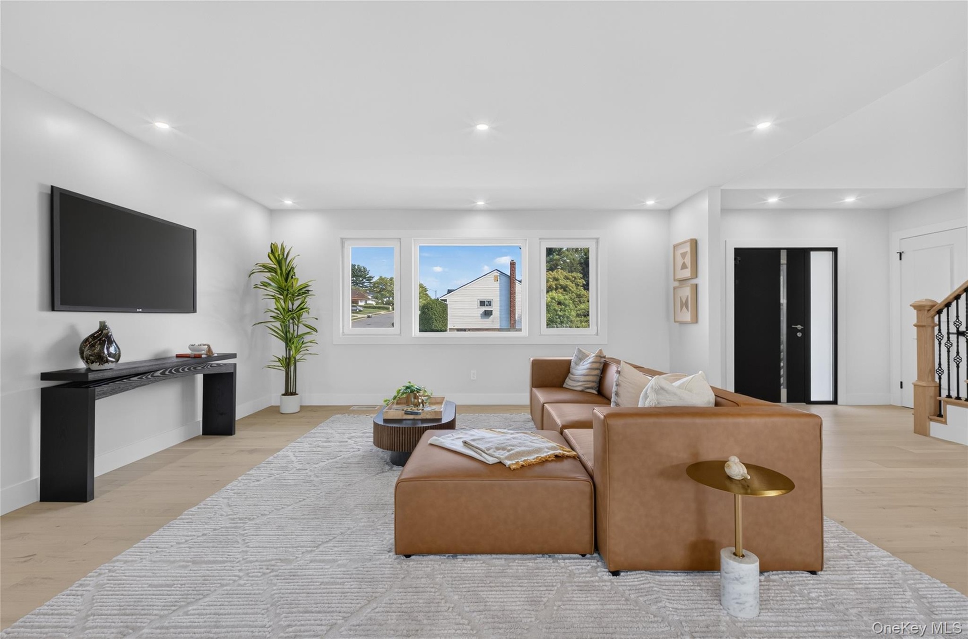 Interior space featuring wood-finish flooring, recessed lighting, and a multi-panel window assembly