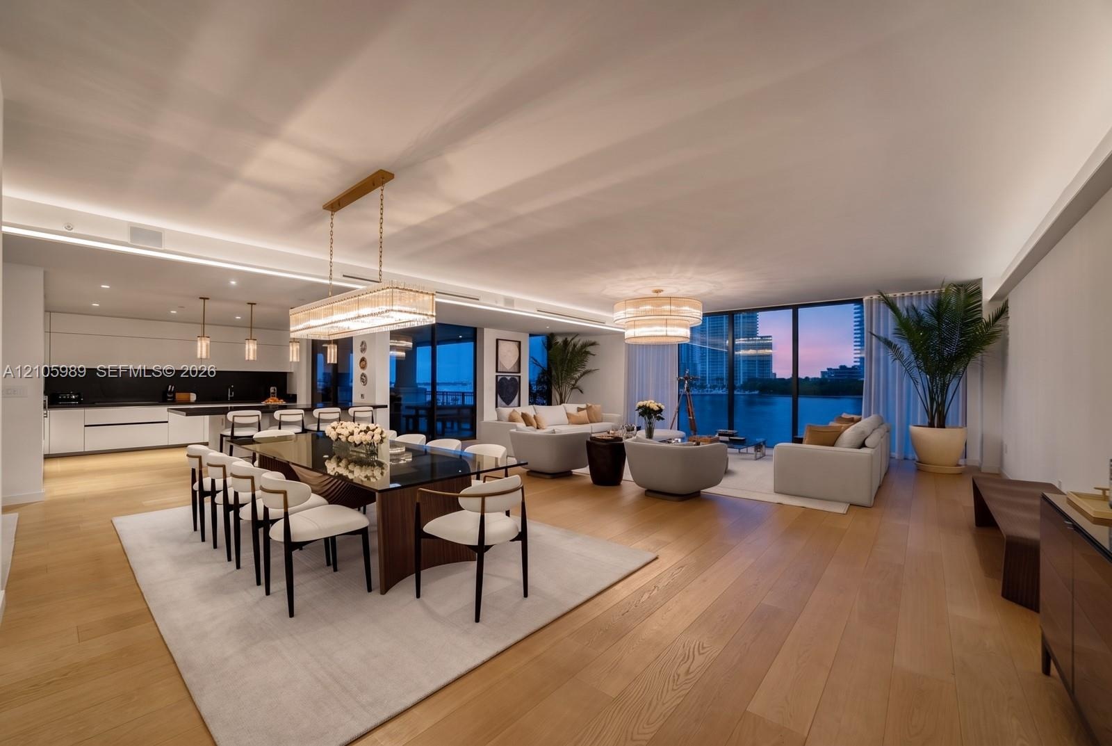 Open-concept interior featuring wood-finish flooring, recessed LED cove lighting, floor-to-ceiling glass windows, contemporary pendant lighting, and f