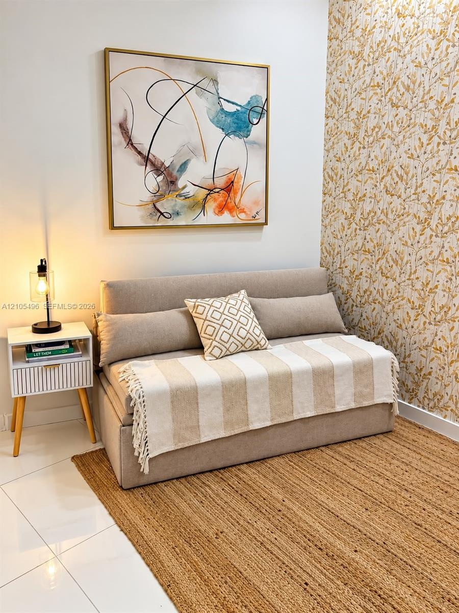 Textured floral patterned wallpaper accent wall and polished tile flooring