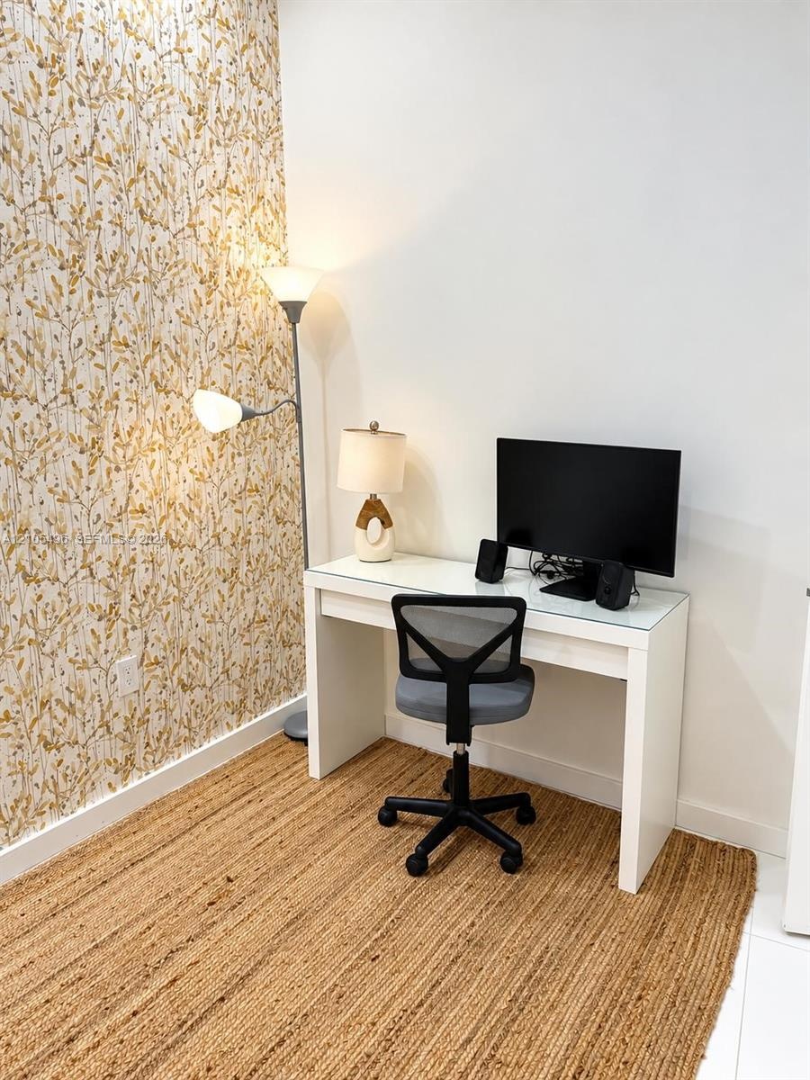 Accent wall featuring a botanical-patterned wallpaper and white flooring