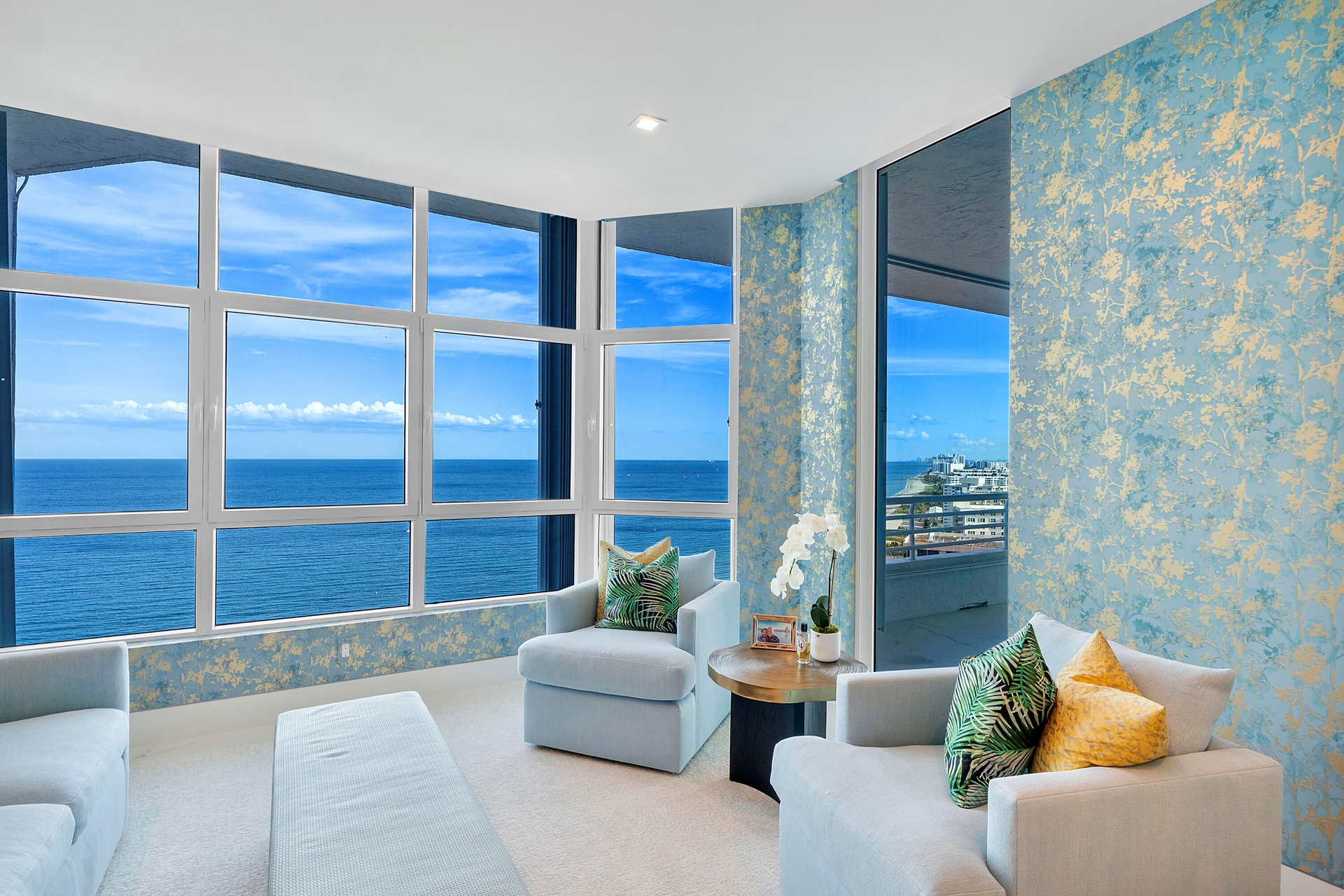 This room tells a story. The wallpaper doesn't compete with the ocean—it complements it. The soft blues and gold accents echo the colors of the sea an