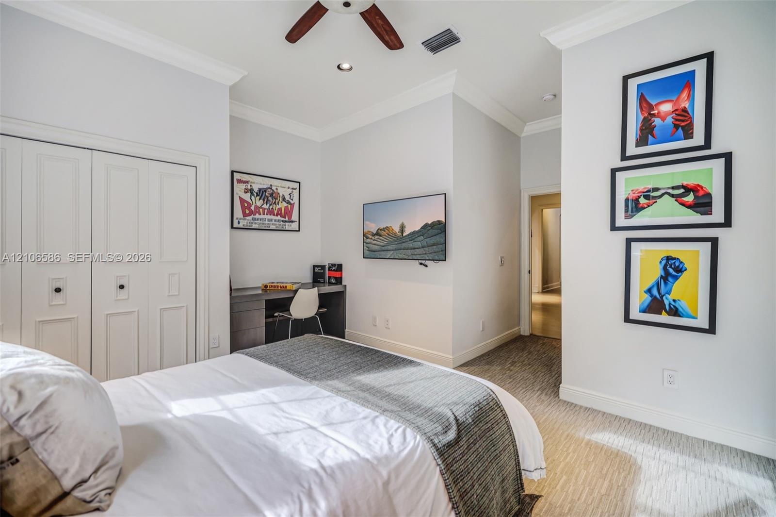 Neutral-toned bedroom featuring recessed lighting, a ceiling fan, carpeted flooring, crown molding, and a built-in desk with cabinetry