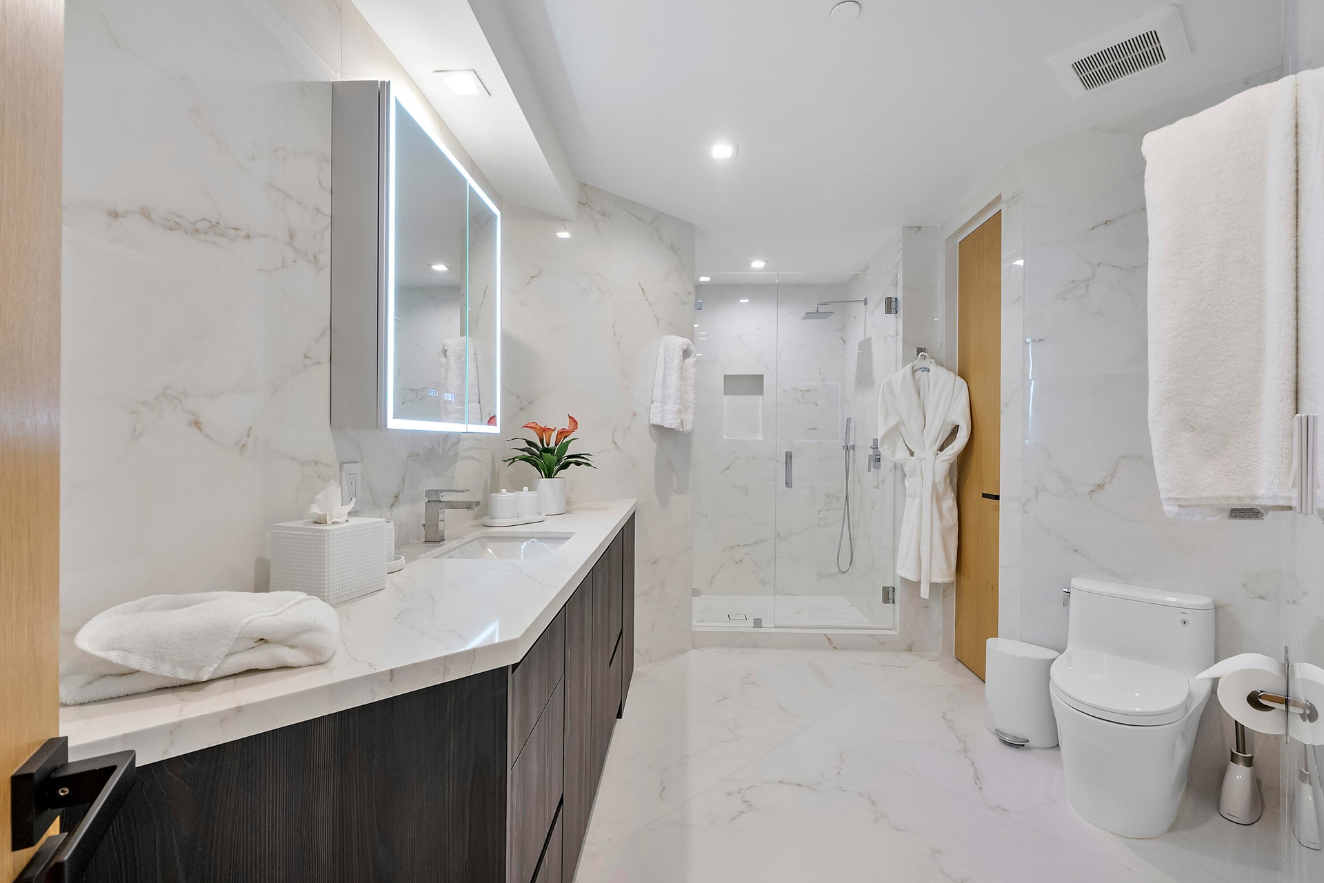 The Mandarin Room’s beautifully appointed private en-suite bath offers a serene counterpoint to the suite’s vibrant palette, enveloped in luminous mar
