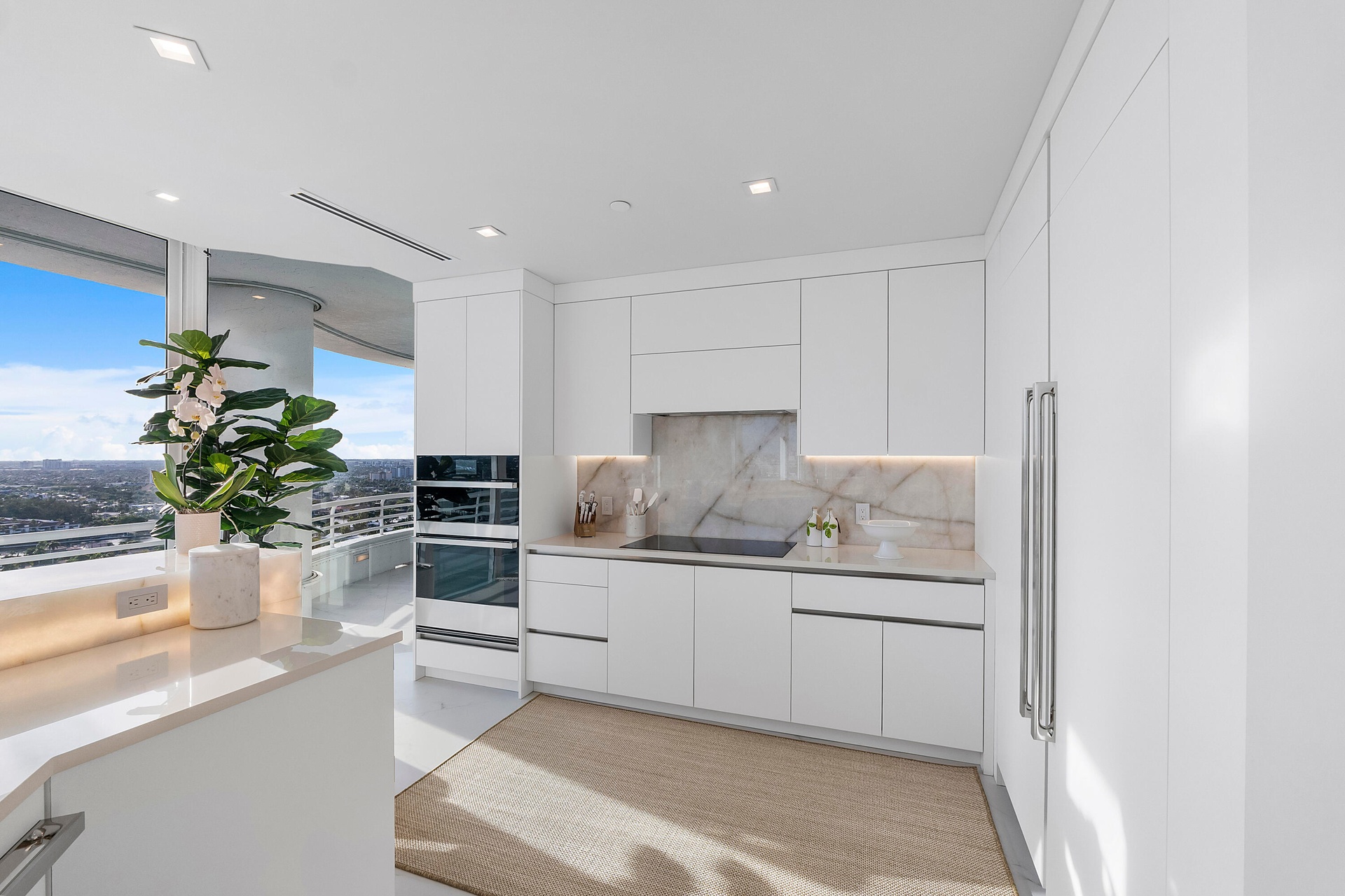 This magnificent chef's kitchen is a masterpiece of contemporary design, where luminous high-gloss white cabinetry is beautifully complemented by besp