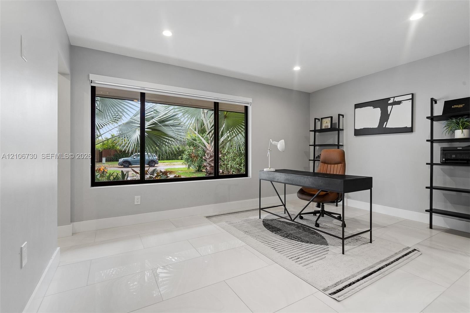 Large picture window with black frames, recessed lighting, and light-toned tile flooring