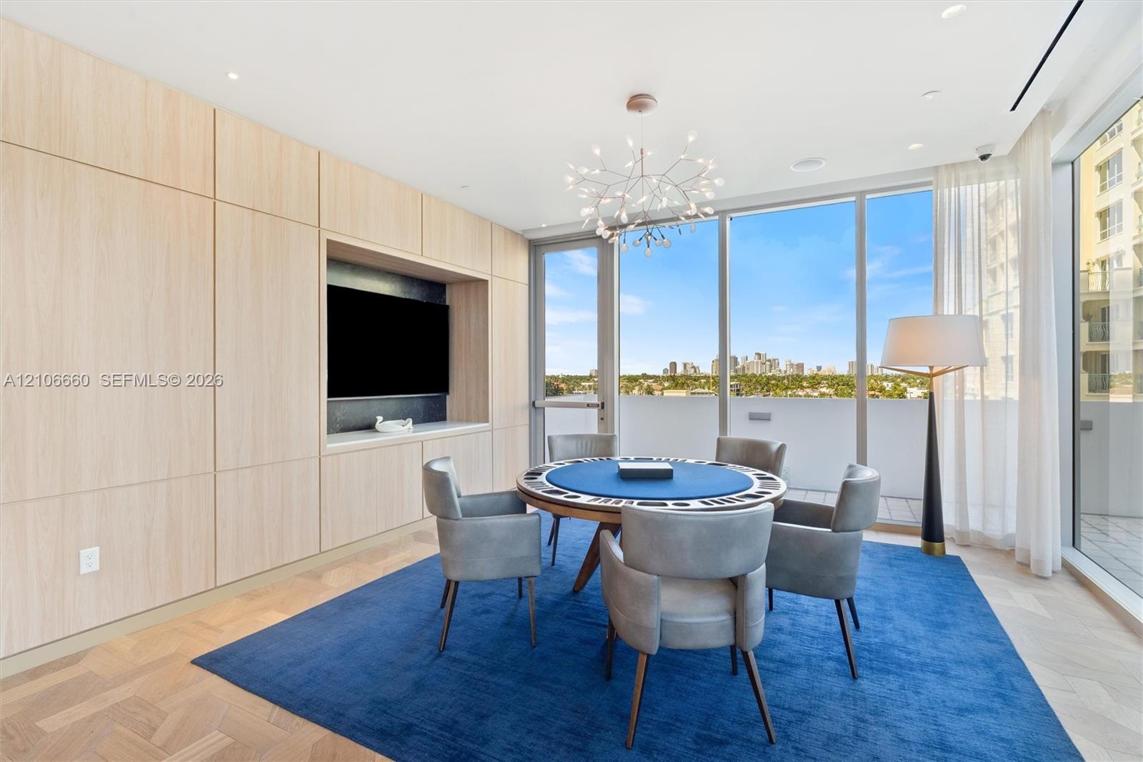 Full-height light wood-finish cabinetry, built-in media alcove, floor-to-ceiling glass wall, recessed lighting, and herringbone wood-finish flooring