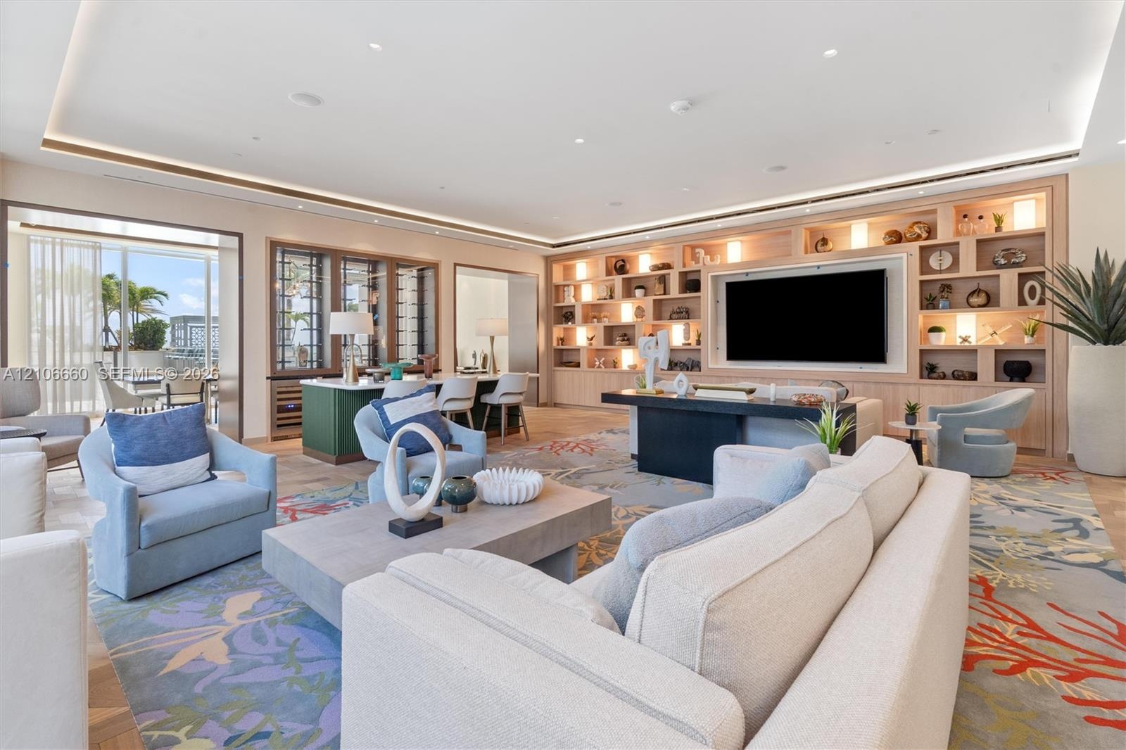 Open-concept room featuring integrated cove lighting, floor-to-ceiling custom wood-finish built-in shelving, wood-finish flooring, and a wine storage 