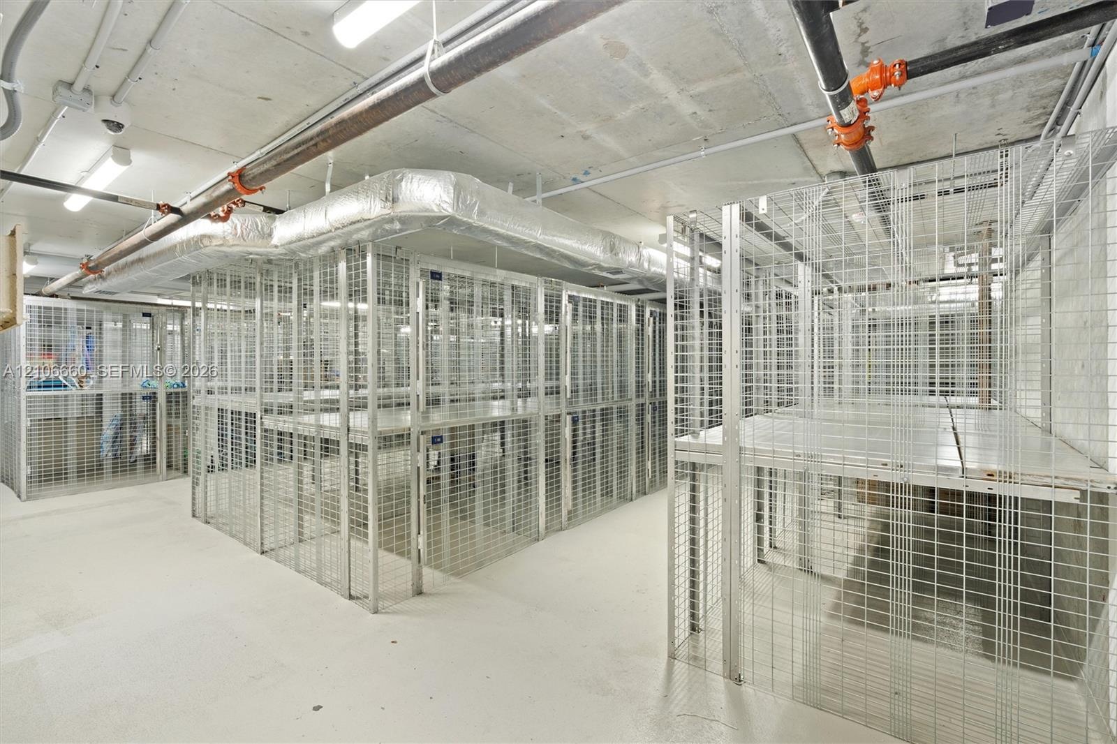 Secure, dedicated wire-mesh storage units with integrated elevated shelving and concrete flooring