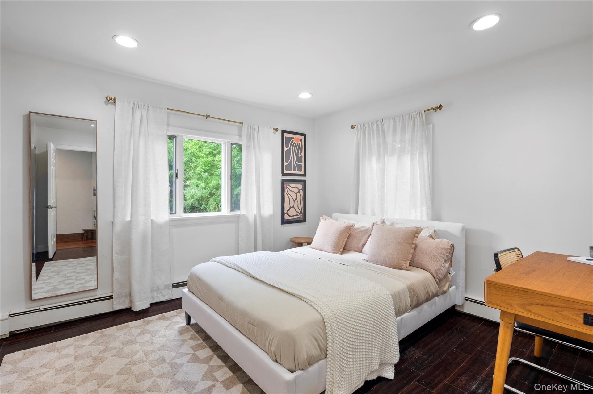 Neutral-toned room featuring dark-finish hardwood flooring, recessed lighting, and multiple windows