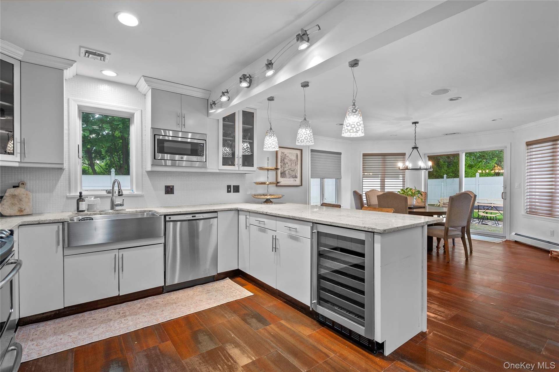 Kitchen featuring white cabinetry, stone-finish countertops, stainless steel farmhouse sink, built-in wine refrigerator, and wood-finish flooring